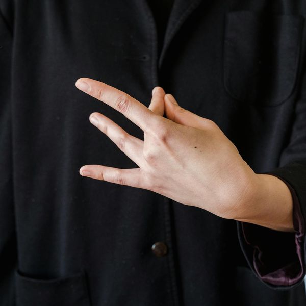 Close-up on a person's hands in a meditative mudra position.