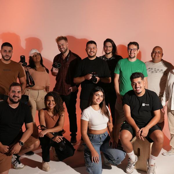 Diverse group of people smiling together in a bright, modern yoga studio.
